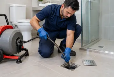 Profissional fazendo desentupimento de um ralo em uma casa em Marituba.
